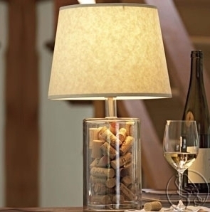 A night lamp attached with a stand made up of corks placed in a table along with a beer bottle and glass.