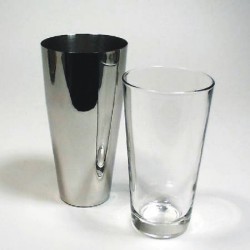 Two beverage cups are lying together - one is made glass and the other is made of steel.