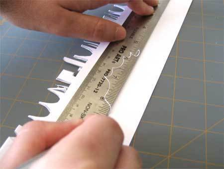 A person is using a ruler on a white object.
