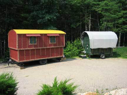 Two gypsy vardos or wagons, one in red and other in green color.