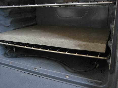 A board sits on a rack in an oven.