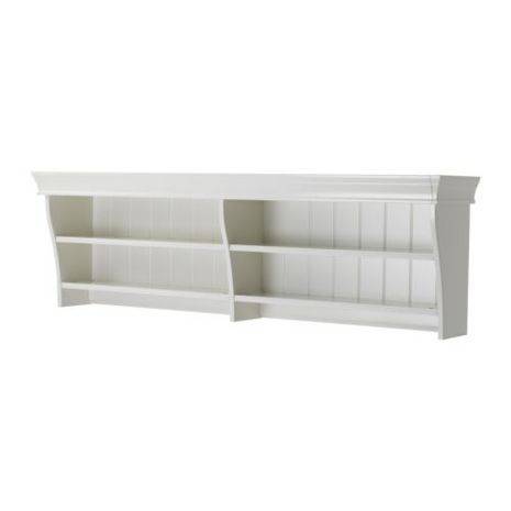 White shelf with two shelves and wide top mounted on a wall.