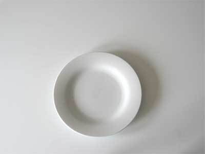 A small white plate on a white table.