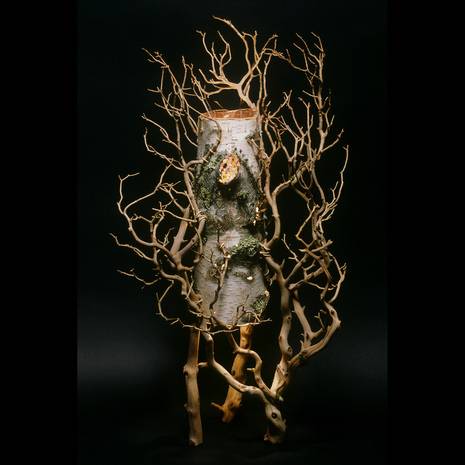 Dead tree shaped light sculpture is prepared with birch bark.