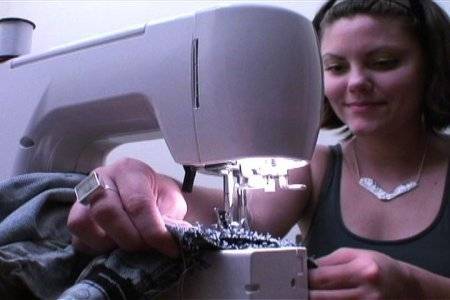 "A lady is stitching in a Sewing Machine"