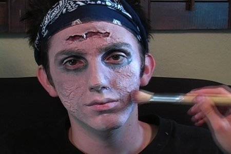 "A Boy doing Zombie Makeup on his face"