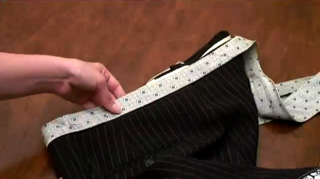 A person sewing pant with another fabric like belt.