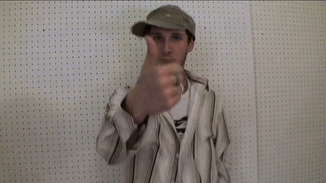 A person with cap is showing thumbs up.