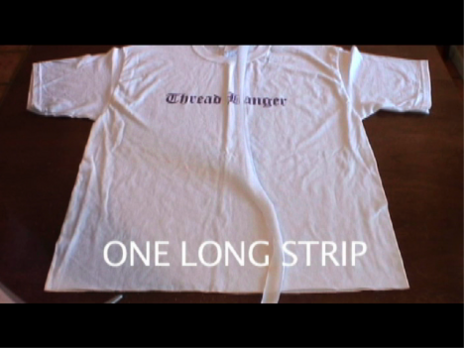 A white t-shirt laying stretched out on a table with two words on it.