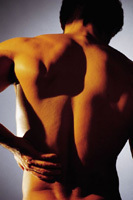 A person is showing his back side and holding his hip with his hand.