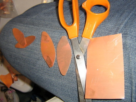 Book cover is cut into oval shapes with scissor for craft.