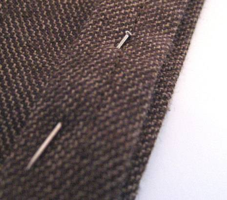 A woollen cloth with a needle piercing that cloth.