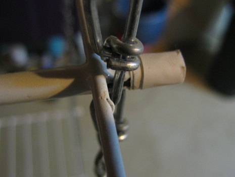 A wire connection with blue and tan rod and another bigger tan rod intersecting the wire.
