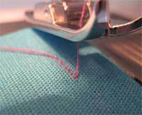 Sewing machine is stitching cloth.