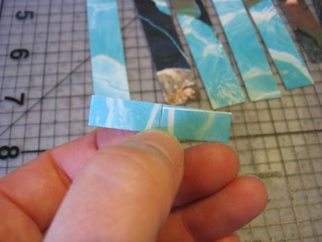 Person showing blue color folded paper strip with his left hand.