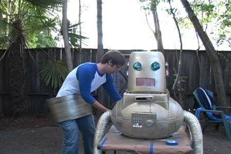 Man preparing robot suit in the backyard of the house.