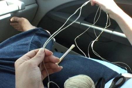 A person untangling yarn in a car.
