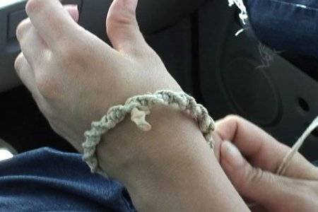 A braided piece of rope around someone's left wrist.