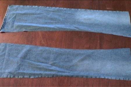 Blue jeans pant leg part cutting pieces are placed separately on the floor.