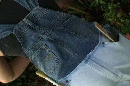 A person wearing overall made of denim with big pockets.