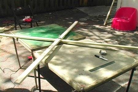 Long slats of wood crossing on top of each other on a table outdoors.