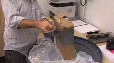 Man using a roll of duct tape to wrap around and close a mold.