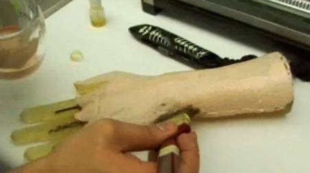 A person making a model of a hand and wrist.