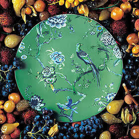 A round flat surface with a decorative trees blossoming and a bird painted on.