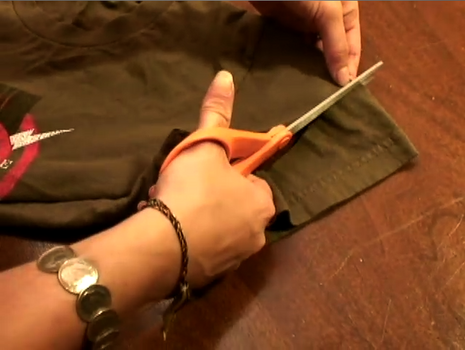 Woman cutting fabric cloth with scissor.