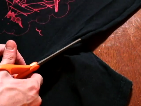 Man is cutting fabric with scissor.