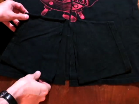 Handling black pieces of fabric over another black T-shirt.