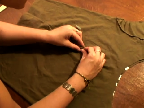 Woman is folding some part of the fabric with hands.