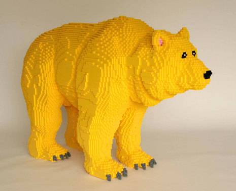 "A  lego sculpture of bear with yellow colour ".