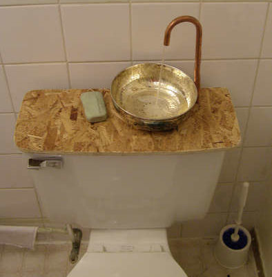 A toilet in the bathtub with a faucet and sink on top of it.