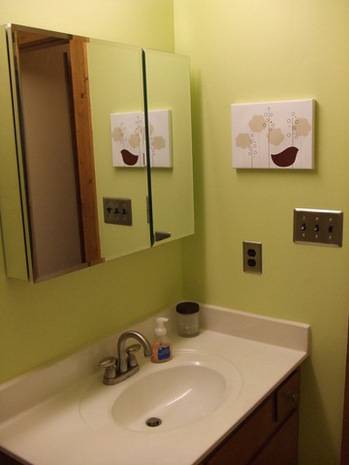 White washbasin with mirror on wall inside the bathroom.