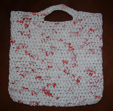 White color bag with crochet and red dots.