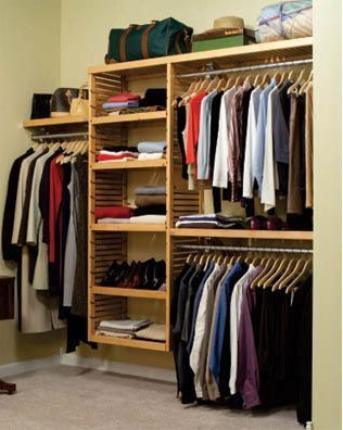 Closet with three racks for hanging as well as shelves lined in the middle.