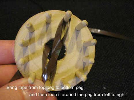 A cassette tape is used along with a daisy loom to create a daisy.