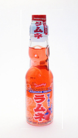 A drink with orange liquid in a clear glass bottle with Japanese type.