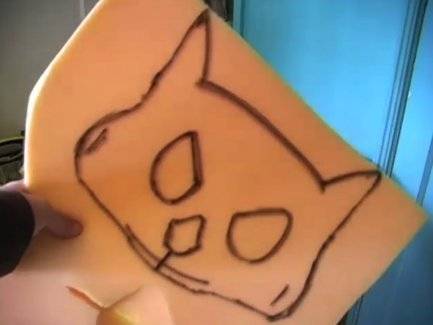 A cat is drawn on a yellow material a child is holding.