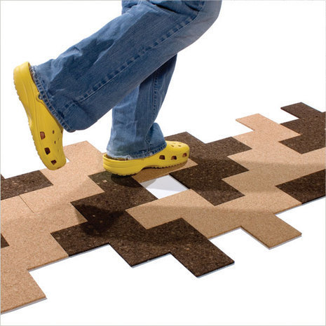 Person walking across brown and dark brown floor tiles made of cork.