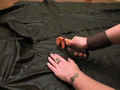 Sewing dark colored costume with hand held sewing machine.