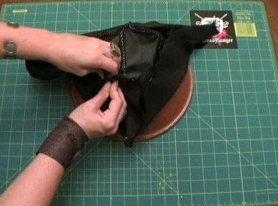 A pair of hands grasping an unfinished pirate cap.