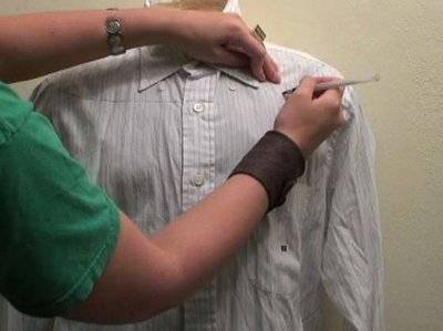 A person decorates a shirt for a pirate costume.