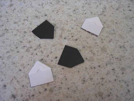 Black and white magnet photo corners on the floor.