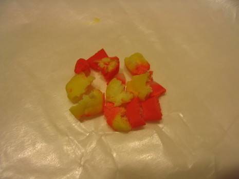 Candy corn fondant pieces are on a plastic wrapper for decoration.