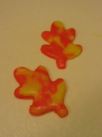 Two yellow and orange candy corn fondant decorations.
