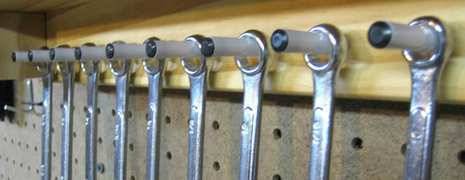 Screw drivers are arranging in a shelf using pens as a hanging stand.