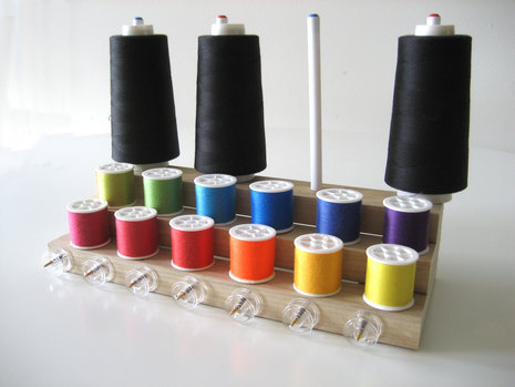 Colourful thread rolls are inserting in the thread stand.