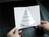 A piece of paper that has a Christmas tree cutout on it.